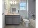 Bathroom with gray cabinets, tub with tile surround and updated fixtures at 4413 Lions Gate Ave, Clermont, FL 34711