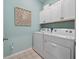 Laundry room with ample storage space and appliances, featuring a modern design at 4413 Lions Gate Ave, Clermont, FL 34711