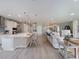 Bright, open-concept area with living room, dining area, and kitchen featuring white cabinets and modern appliances at 4413 Lions Gate Ave, Clermont, FL 34711