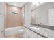 Well lit bathroom with granite counters, white cabinets and tub with tiled walls at 4780 Sw 129Th Pl, Ocala, FL 34473