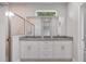 Bathroom with dual sinks, granite countertops, large mirror, and glass shower at 4780 Sw 129Th Pl, Ocala, FL 34473