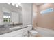 Bathroom featuring granite countertops, vanity, and tub with tiled shower and window at 4780 Sw 129Th Pl, Ocala, FL 34473