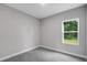 Bedroom featuring gray carpet, gray walls, and a window at 4780 Sw 129Th Pl, Ocala, FL 34473