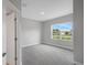 Bright bedroom with plush gray carpet, neutral paint, and a large window overlooking the outdoors at 4780 Sw 129Th Pl, Ocala, FL 34473