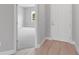 Inviting entryway with wood-look flooring, neutral paint, and carpeted bedroom visible through the doorway at 4780 Sw 129Th Pl, Ocala, FL 34473