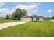 A single-story home with a manicured lawn, driveway, and a two-car garage in a landscaped yard at 4780 Sw 129Th Pl, Ocala, FL 34473
