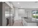 Modern kitchen with stainless steel appliances, granite countertops, white cabinets, and wood laminate flooring at 4780 Sw 129Th Pl, Ocala, FL 34473