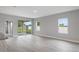 Bright living room with light wood flooring, a sliding glass door to the patio, and two windows at 4780 Sw 129Th Pl, Ocala, FL 34473