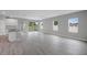 Bright, open-concept living area with gray-toned wood flooring and sliding glass doors to the backyard at 4780 Sw 129Th Pl, Ocala, FL 34473