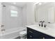 Stylish bathroom boasts a navy vanity, elegant fixtures, and a tiled shower-tub combination at 4858 Brenda Dr, Orlando, FL 32812