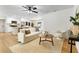 Bright, open-concept living room features stylish furnishings, and flows into the modern white kitchen beyond at 4858 Brenda Dr, Orlando, FL 32812
