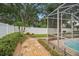 Secluded backyard featuring a stone path, privacy fence, mature landscaping, and screened-in pool area at 489 Penny Ln, Maitland, FL 32751