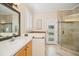 Bright bathroom featuring a walk-in shower, garden tub, and white cabinets at 489 Penny Ln, Maitland, FL 32751