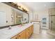 Spacious bathroom featuring a double vanity, tiled shower, and exterior access at 489 Penny Ln, Maitland, FL 32751