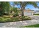 Charming single-Gathering home featuring a two-car garage, palm trees and lush landscaping at 489 Penny Ln, Maitland, FL 32751