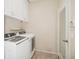 Well-lit laundry room with washer, dryer, and ample cabinet space with tiled floor at 489 Penny Ln, Maitland, FL 32751