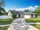 Inviting home with a curved driveway, white fence, well-kept lawn, and attached two-car garage at 4942 Eden View Ct, Orlando, FL 32810
