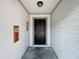 Inviting front porch with a black door, neutral walls, and a decorative wall art at 4942 Eden View Ct, Orlando, FL 32810