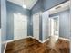 Hallway with wood floors, blue walls, closet space, and access to the bathroom at 4942 Eden View Ct, Orlando, FL 32810
