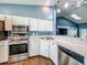 Modern kitchen featuring white cabinets, stainless steel appliances, and marble countertops at 4942 Eden View Ct, Orlando, FL 32810