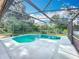 A screened in pool with a beautiful blue water and outdoor string lights at 4942 Eden View Ct, Orlando, FL 32810