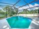 An inviting in-ground pool enclosed by a screened lanai and surrounded by lush landscaping at 4942 Eden View Ct, Orlando, FL 32810
