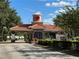 A scenic community entrance with beautiful architecture, tiled roof, stone accents and manicured landscaping at 541 Arena Dr, Davenport, FL 33837