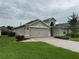 A well-kept home with a two-car garage, green lawn, and neat landscaping in a quiet neighborhood at 541 Arena Dr, Davenport, FL 33837