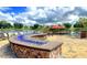 Stunning outdoor fire pit area by the lake with stone surround and comfortable seating at 541 Arena Dr, Davenport, FL 33837