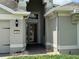 A well-lit home entrance featuring a storm door, brick pathway, and stylish exterior finishes at 541 Arena Dr, Davenport, FL 33837