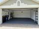 Open garage with epoxy flooring, shelving, storage and space for two cars at 541 Arena Dr, Davenport, FL 33837