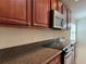 Granite countertops and dark cabinets highlight this kitchen with stainless microwave and electric stove at 541 Arena Dr, Davenport, FL 33837