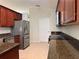 Kitchen showcasing granite countertops, stainless steel appliances, and dark wood cabinets at 541 Arena Dr, Davenport, FL 33837