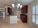Open kitchen featuring stainless steel appliances, dark cabinetry, and tile floors throughout the space at 541 Arena Dr, Davenport, FL 33837