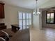 Bright and airy living room with tiled floor, ceiling fan, large windows and a glass paneled door at 541 Arena Dr, Davenport, FL 33837