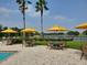 Inviting poolside seating area with tables, chairs, umbrellas, and a beautiful lake view at 541 Arena Dr, Davenport, FL 33837