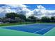 Bright tennis court with blue and green surface, black fence, and picturesque sky in a desirable community at 541 Arena Dr, Davenport, FL 33837
