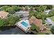 Aerial view featuring a community pool, tennis court, and scenic pond surrounded by lush greenery and residences at 5436 E Michigan St # 7, Orlando, FL 32812