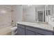 Bright bathroom featuring a granite countertop, tub-shower combo with tiled walls, and sleek fixtures at 5436 E Michigan St # 7, Orlando, FL 32812