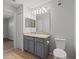 Bathroom featuring granite counters, gray cabinets, tile floors, and a framed vanity mirror at 5436 E Michigan St # 7, Orlando, FL 32812