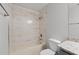 A bathroom showcasing a tub-shower combo with tiled walls, neutral color palette, and practical design at 5436 E Michigan St # 7, Orlando, FL 32812