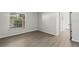 This bright bedroom features neutral walls, wood-look floors, and a window with a view at 5436 E Michigan St # 7, Orlando, FL 32812
