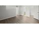 An open bedroom showing gray walls, wood-look floors, and a door that leads to the bathroom at 5436 E Michigan St # 7, Orlando, FL 32812