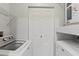 Efficient laundry area with washer, dryer, shelving and storage ensuring functional space for chores at 5436 E Michigan St # 7, Orlando, FL 32812