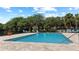 Outdoor pool area with lounge chairs, lush trees, and a serene ambiance for relaxation and recreation at 5436 E Michigan St # 7, Orlando, FL 32812