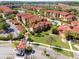 Wide aerial of the condo buildings and landscape with a lake and roadways in the background at 5500 Metrowest Blvd # 203, Orlando, FL 32811