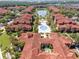 An aerial view of a resort-style community with a large pool and a central lake at 5500 Metrowest Blvd # 203, Orlando, FL 32811