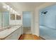 Bathroom featuring a sink, granite counters, wooden flooring and a view into the walk-in closet and bedroom at 5500 Metrowest Blvd # 203, Orlando, FL 32811