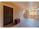 Apartment 203's front door with dark brown finish in a stucco-walled hallway at 5500 Metrowest Blvd # 203, Orlando, FL 32811