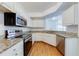 Well-lit kitchen with stainless steel appliances, granite countertops, and a view of the living space at 5500 Metrowest Blvd # 203, Orlando, FL 32811